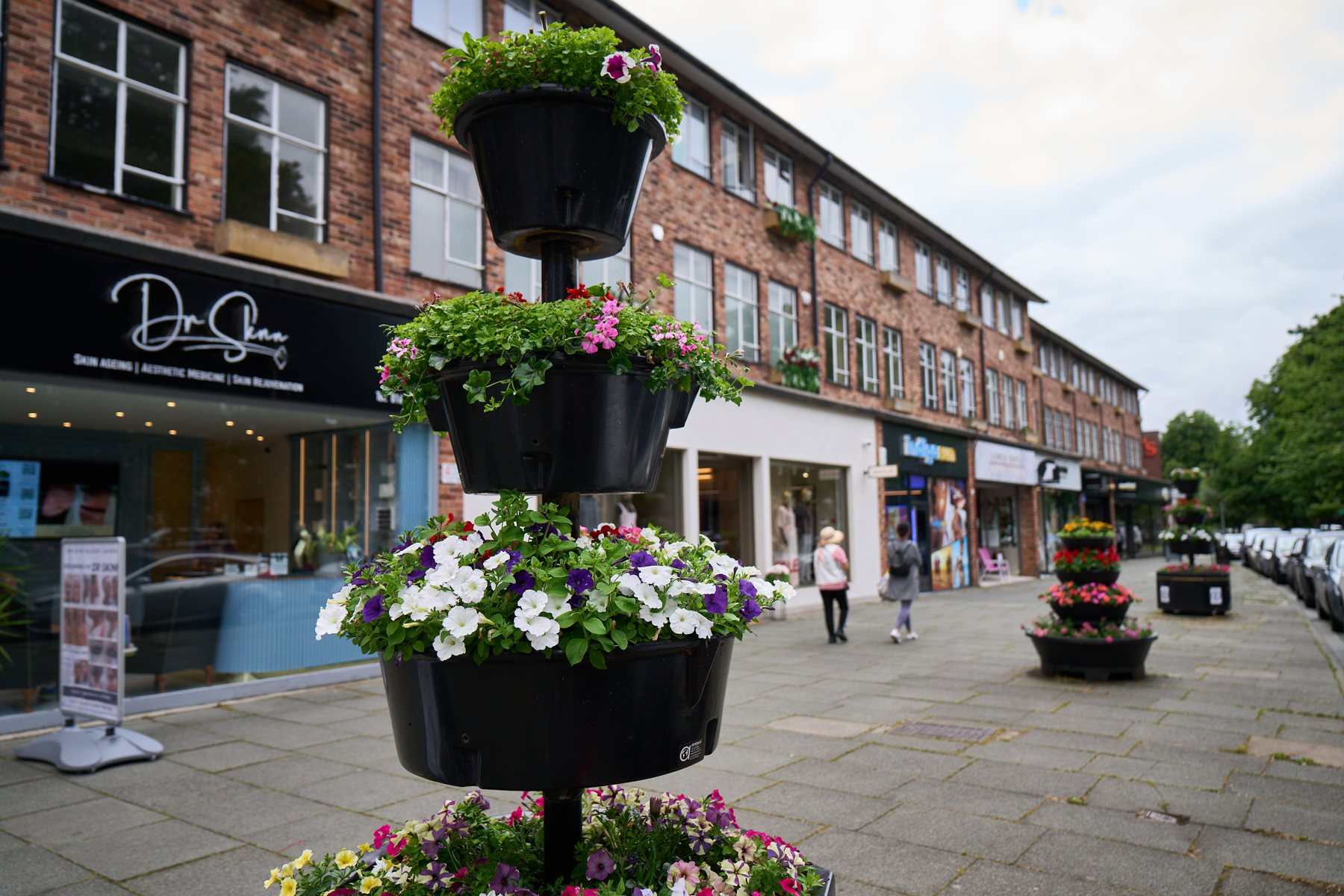 Shops and flowers on a street in Wilmslow