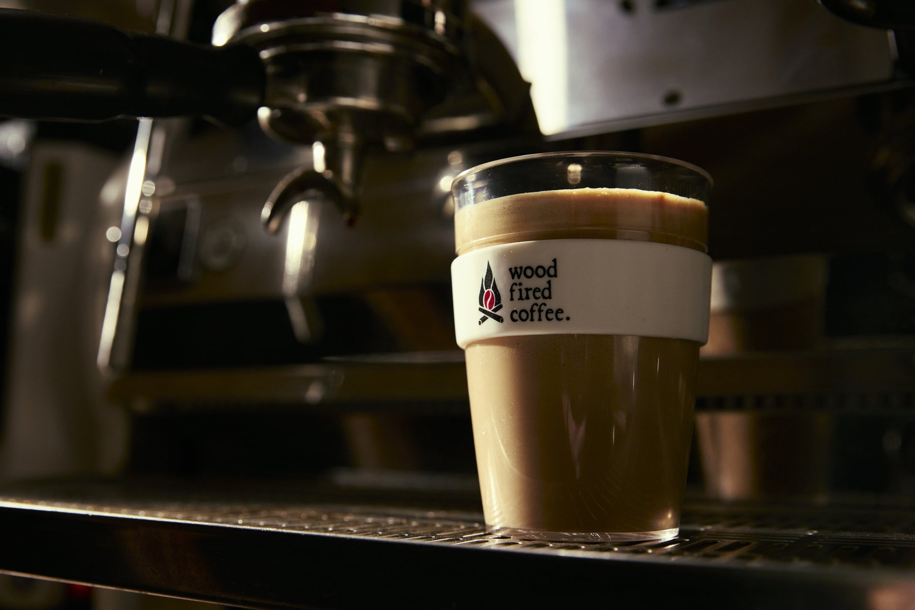 Wood Fired Coffee cup beside a coffee machine